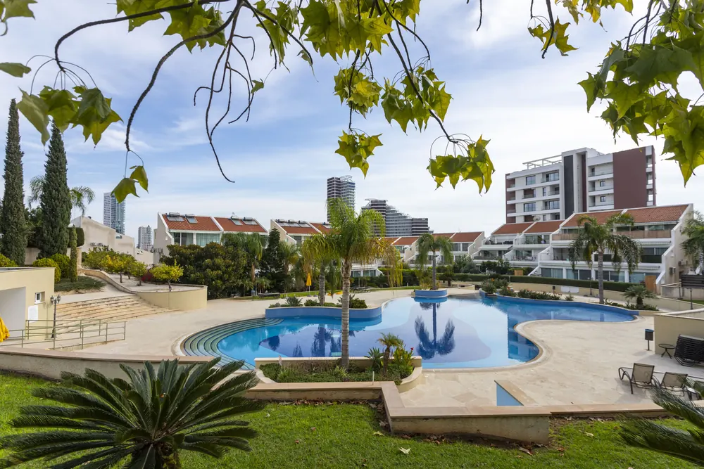 The Bayview Gardens pool and gardens with the Limassol skyline behind