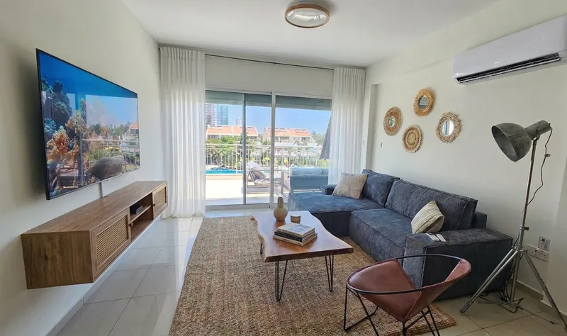 Living room of the Azure Haven holiday apartment in Limassol with sofa, TV and doors to the balcony